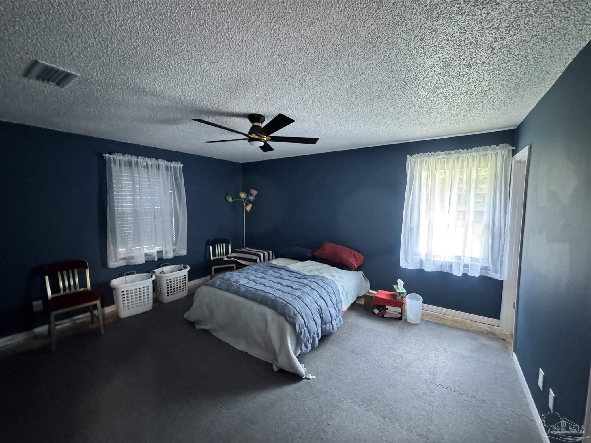 7210 Belgium Road Pensacola, FL 32526 - Photo 14 of 37 a bedroom with a bed and a chandelier