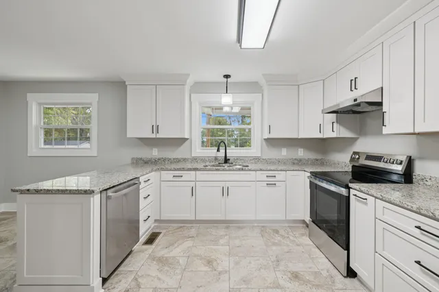 a kitchen with granite countertop white cabinets white appliances and sink