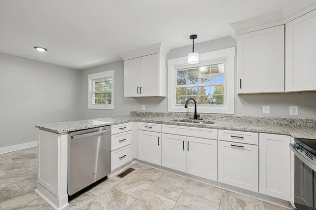 a kitchen with granite countertop white cabinets and appliances