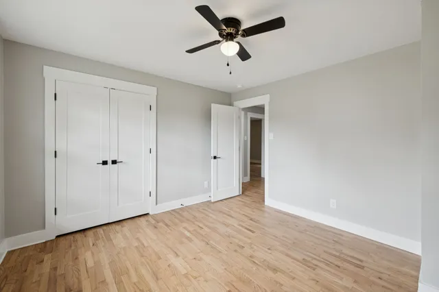 a view of a big room with wooden floor and windows