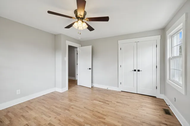 a view of a big room with wooden floor and windows in a room