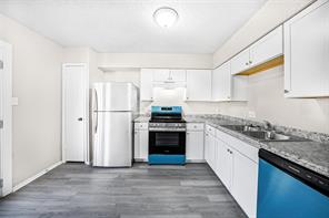 1111 West Rundberg Lane Austin, TX 78758 - Photo 1 of 6 Kitchen featuring white cabinetry, a stainless steel refrigerator, and a blue and black range and dishwasher