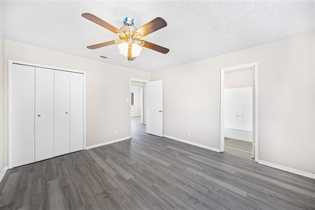 1111 West Rundberg Lane Austin, TX 78758 - Photo 3 of 6 Room featuring wood-look flooring, light-colored walls, a ceiling fan with integrated lighting, and white bi-fold closet doors