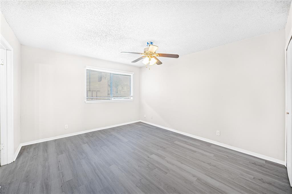 1111 West Rundberg Lane Austin, TX 78758 - Photo 4 of 6 This room features gray plank flooring, white walls, and a window with blinds