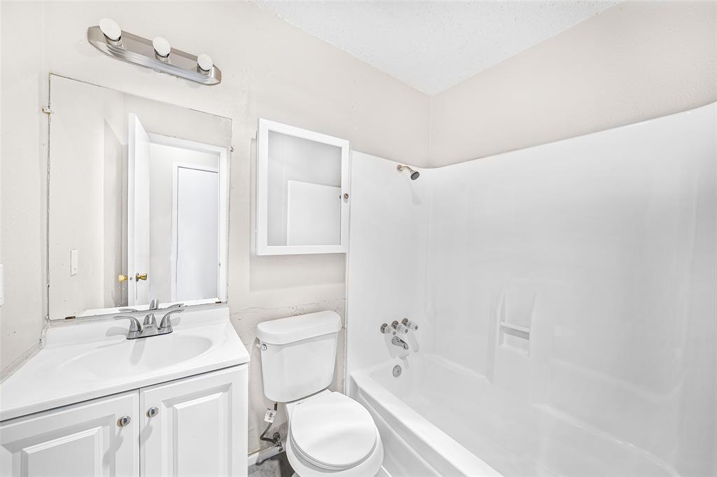 1111 West Rundberg Lane Austin, TX 78758 - Photo 5 of 6 Bathroom featuring a white vanity with a sink, a toilet, and a shower-tub combination