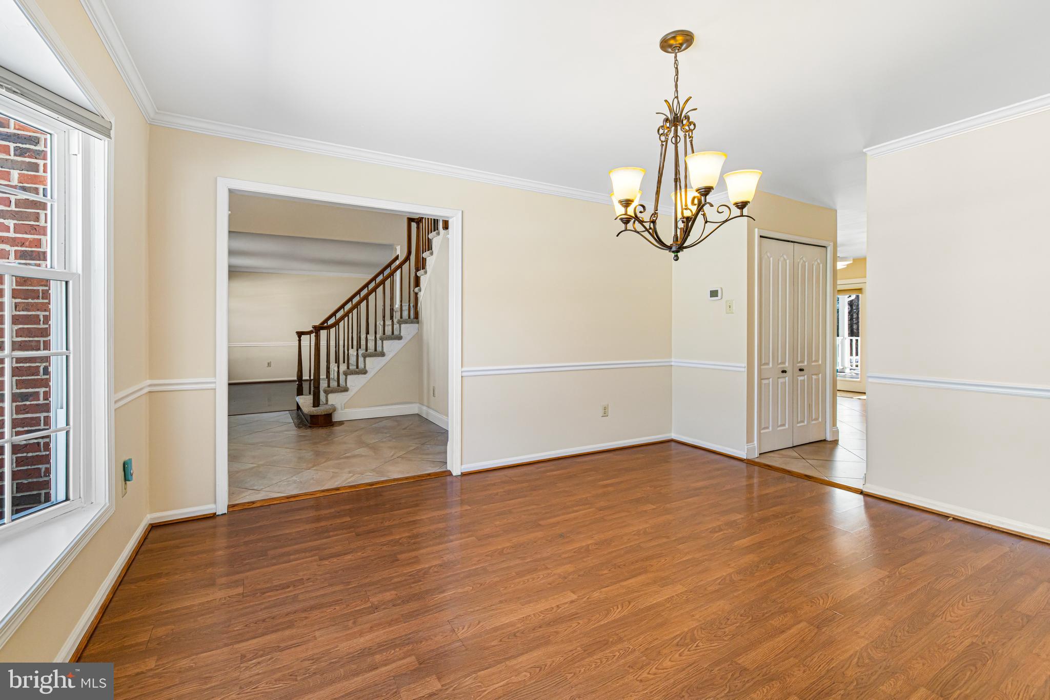2249 Lilac Lane Jamison, PA 18929 - Photo 15 of 61 an empty room with wooden floor staircase and a chandelier