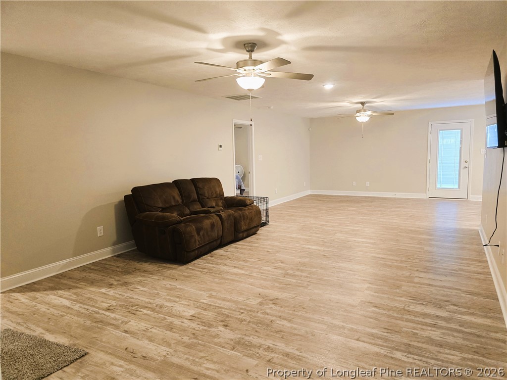 422 Mitchell Farm Road Goldsboro, NC 27530 - Photo 15 of 28 a view of a livingroom with a ceiling fan and wooden floor