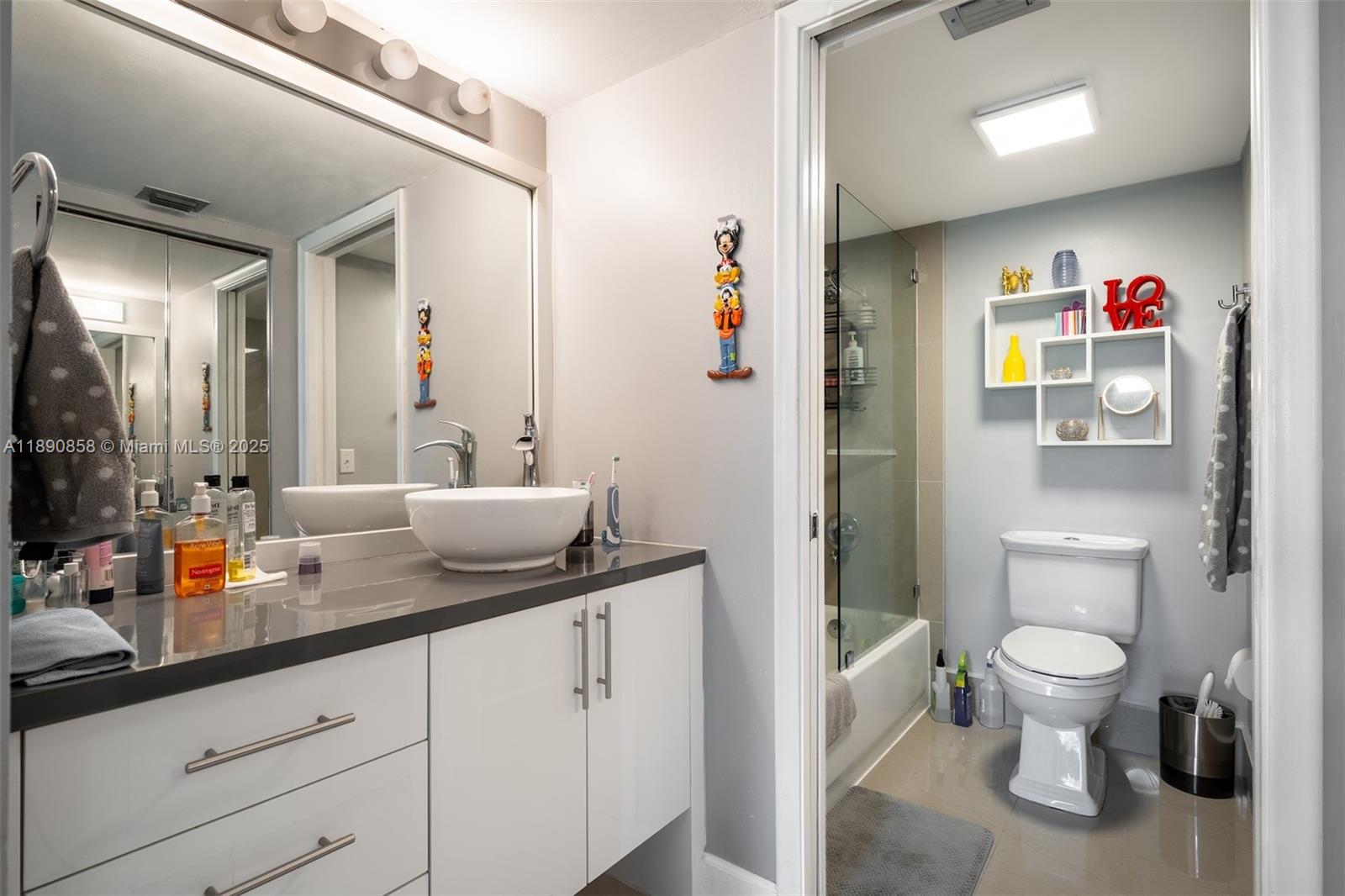 1201 Southwest 128th Terrace, Unit 407E Pembroke Pines, FL 33027 - Photo 12 of 26 a spacious bathroom with a granite countertop sink a toilet a mirror and shower