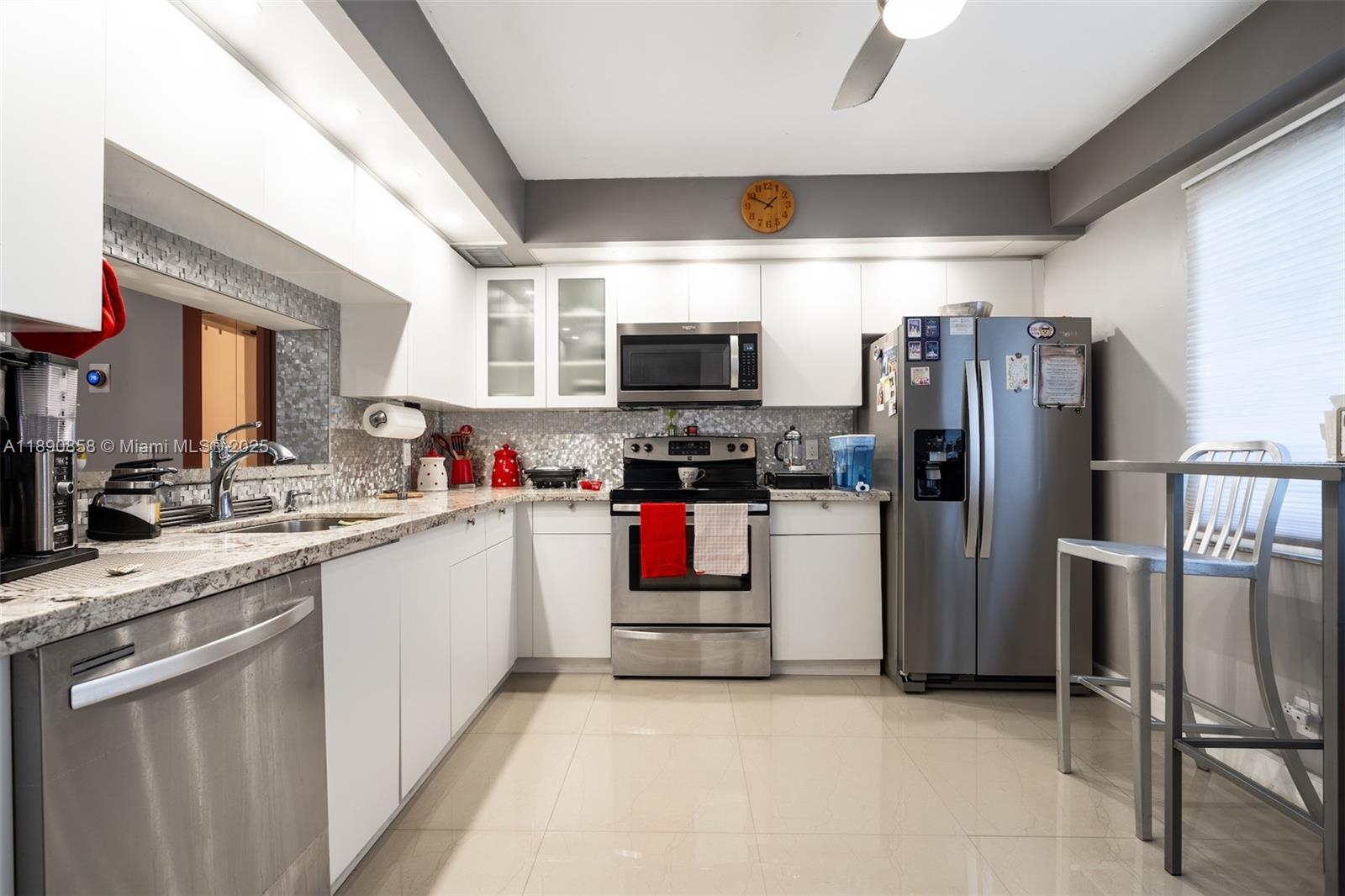 1201 Southwest 128th Terrace, Unit 407E Pembroke Pines, FL 33027 - Photo 9 of 26 a kitchen with refrigerator and microwave