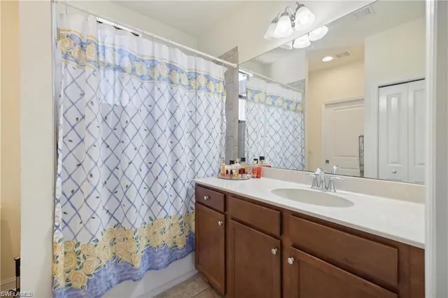 a bathroom with a sink a mirror and a shower curtain