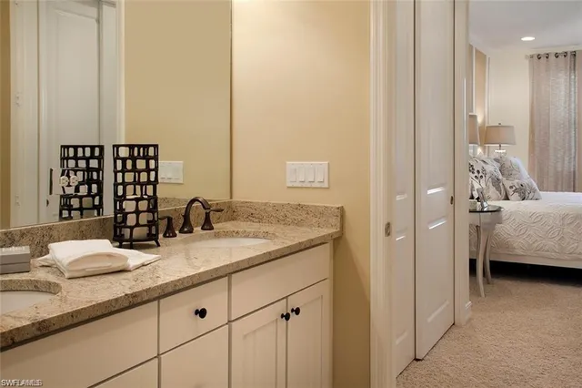 a en suite bathroom with a granite countertop sink and a mirror