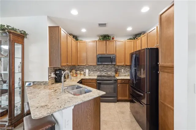 a kitchen with stainless steel appliances granite countertop a refrigerator and a sink