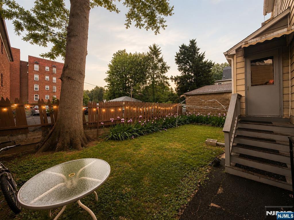 102 State Street Bloomfield, NJ 07003 - Photo 10 of 11 a view of a backyard with table and chairs potted plants with wooden fence