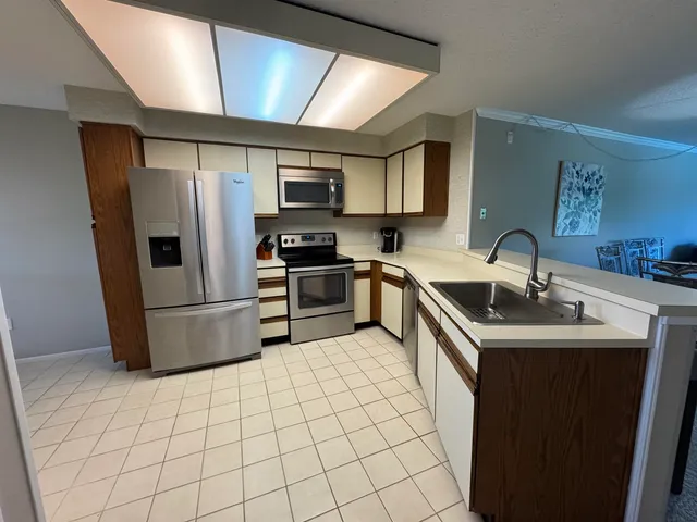 a kitchen with stainless steel appliances granite countertop a refrigerator oven a sink and dishwasher