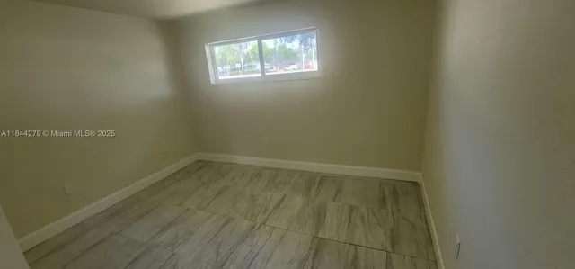 a view of a small space with wooden floor and a window