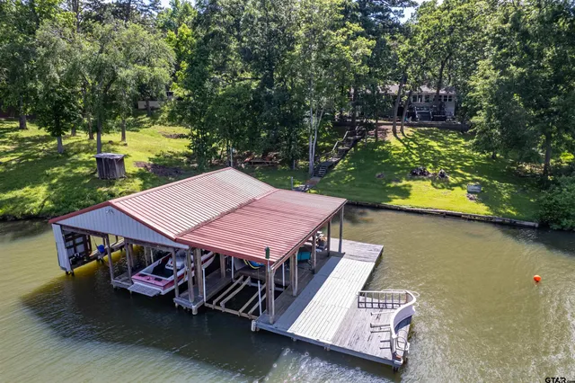 a view of a patio with table and chairs with wooden floor and fence