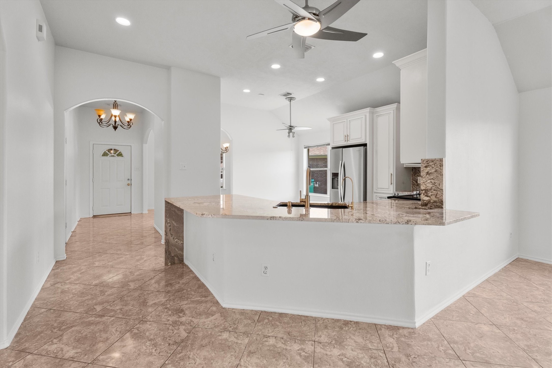 2507 Grayfeather Court Spring, TX 77388 - Photo 15 of 37 This spacious kitchen features elegant countertops, a modern stainless steel refrigerator, and ample natural light. The open layout flows seamlessly into the dining area, highlighted by stylish ceiling fans and recessed lighting.
