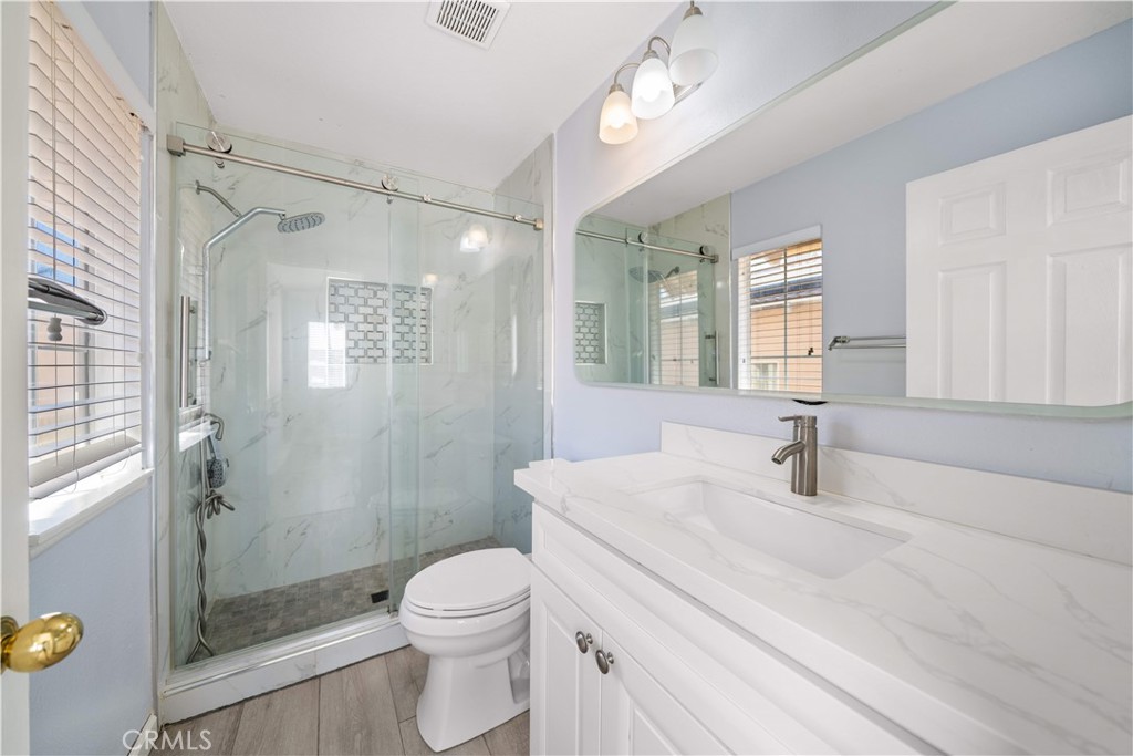 688 North Rimsdale Avenue, Unit 13 Covina, CA 91722 - Photo 39 of 52 a bathroom with a granite countertop sink a toilet a mirror and shower