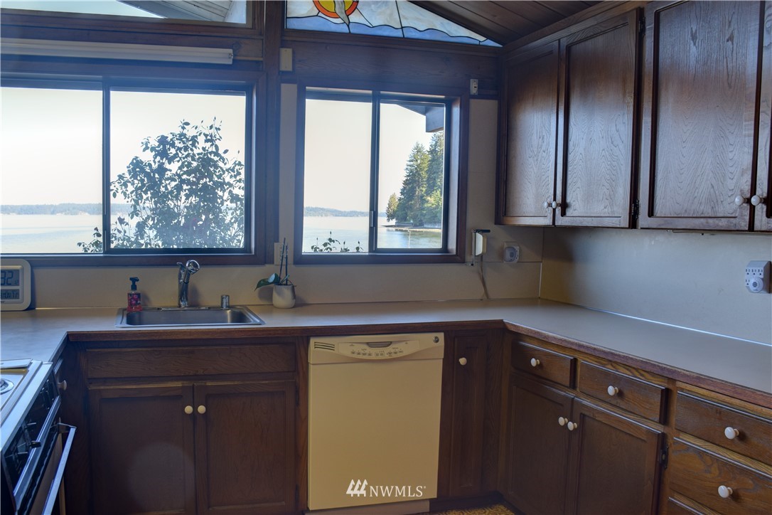7130 Sandy Point Road Northeast Olympia, WA 98516 - Photo 9 of 32 a kitchen with a sink window and cabinets