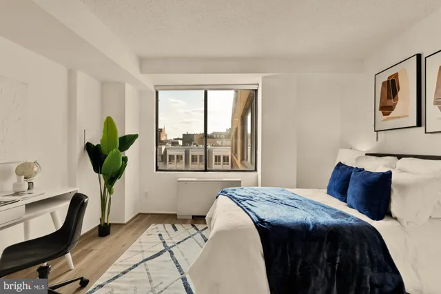 a bedroom with a bed a chandelier and a window