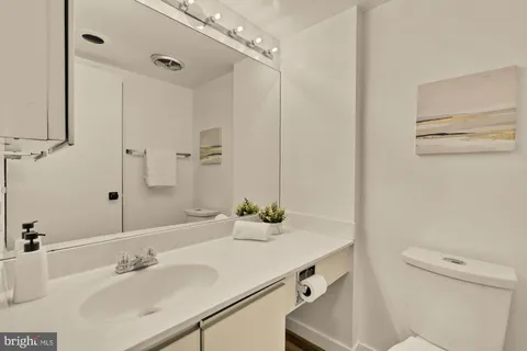 a bathroom with a sink and a mirror with toilet
