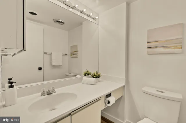 a bathroom with a sink and a mirror with toilet