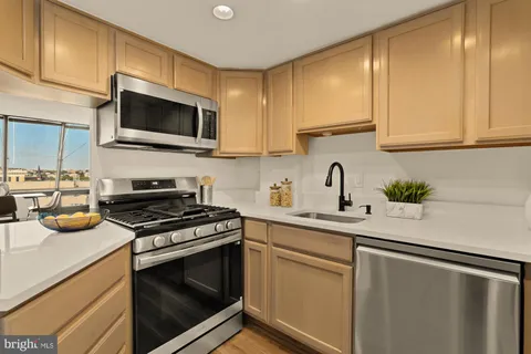 a kitchen with stainless steel appliances granite countertop a sink stove and microwave with wooden floor
