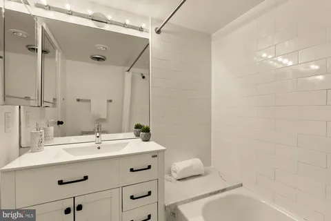 a bathroom with a sink mirror and a bathtub