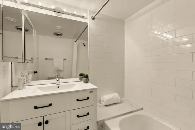 a bathroom with a sink mirror and a bathtub