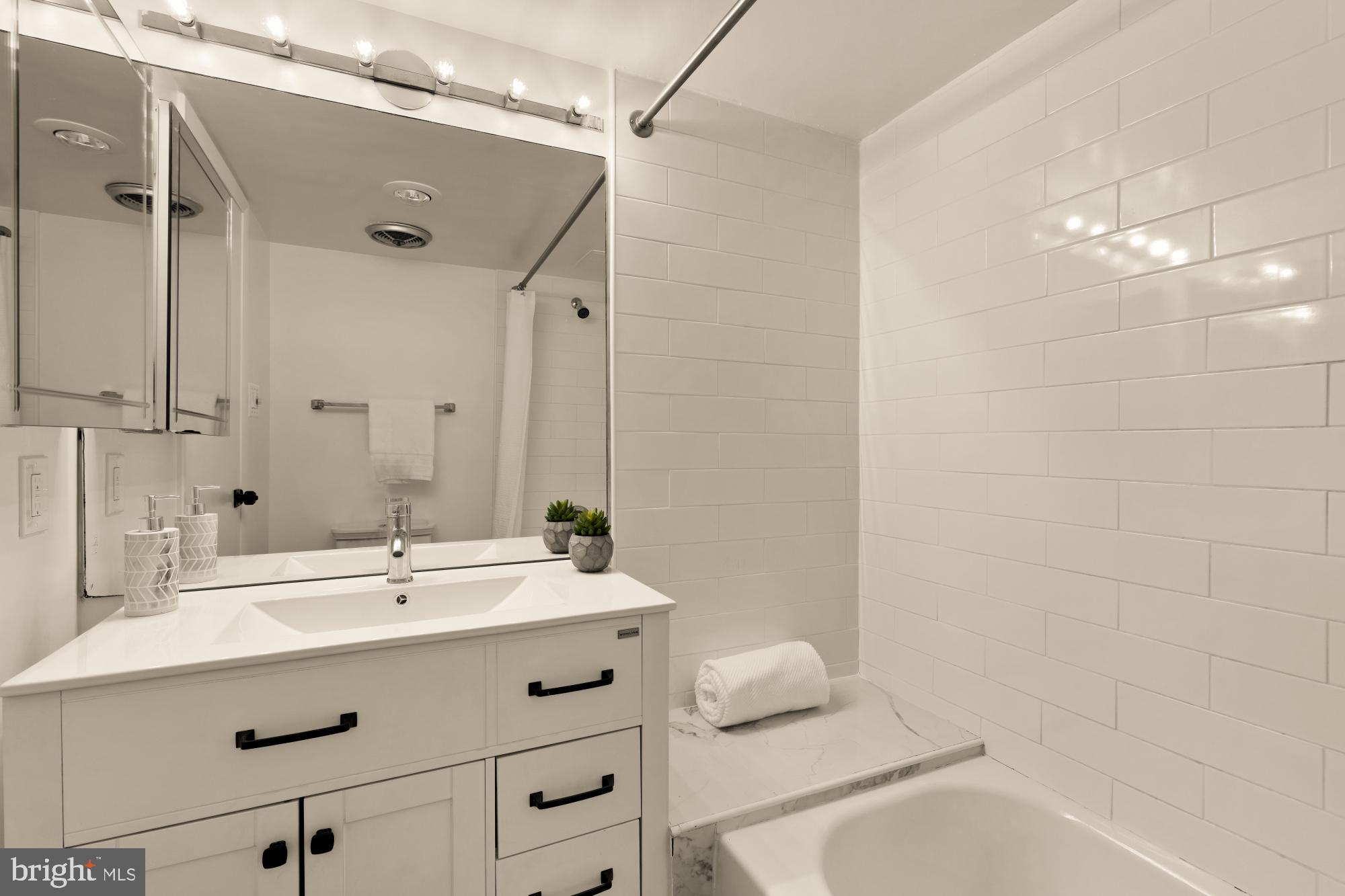 1245 13th Street Northwest, Unit 907 Washington, DC 20005 - Photo 9 of 27 a bathroom with a sink mirror and a bathtub