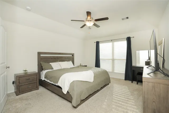 a bedroom with a large bed and a large window