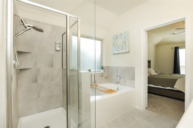 a en suite spacious bathroom with a tub shower and mirror