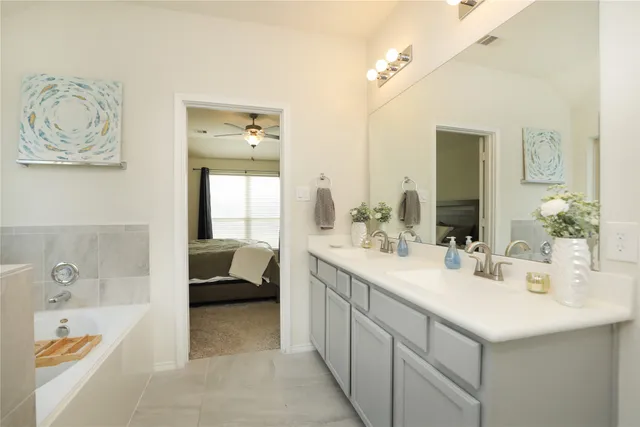 a en suite bathroom with a tub sink and mirror