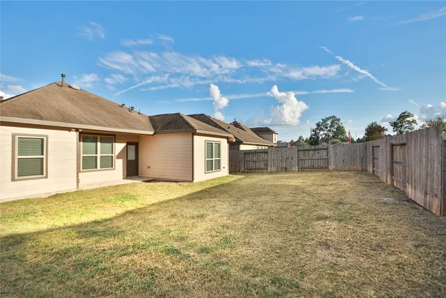 a view of a house with a yard and wooden fence