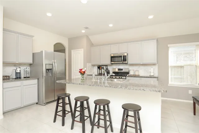 a kitchen with stainless steel appliances granite countertop a refrigerator and a stove top oven