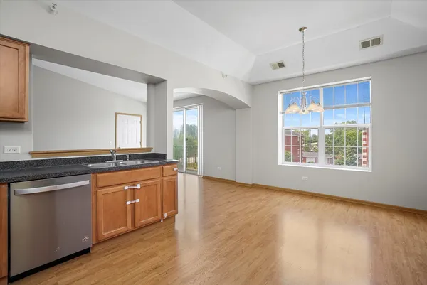 a large kitchen with stainless steel appliances granite countertop a stove a sink and a large window