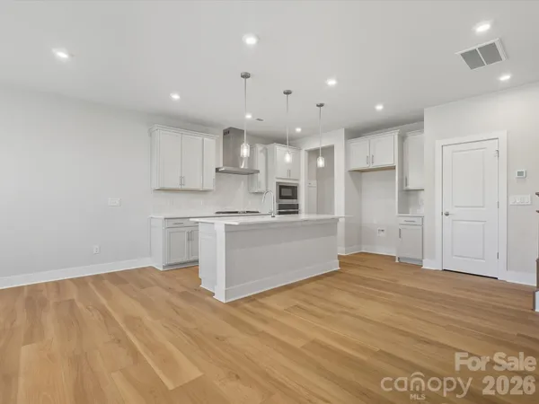 a large kitchen with stainless steel appliances granite countertop a stove a sink and a refrigerator