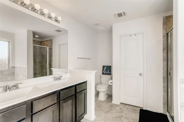 a bathroom with a sink double vanity and a toilet