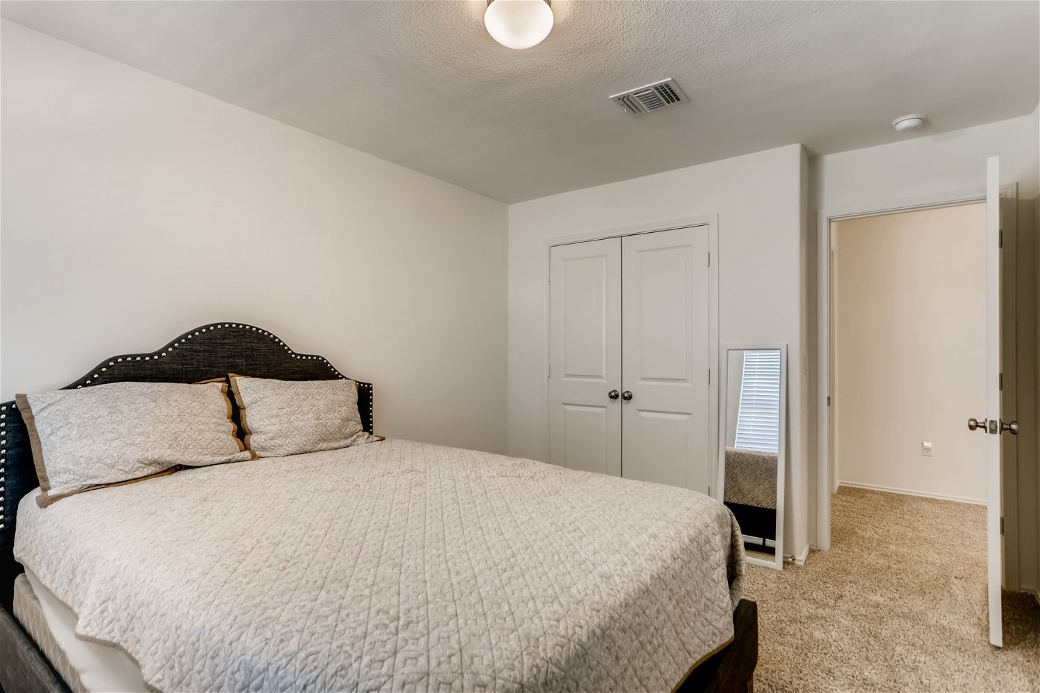 3901 Fort Collins Way Austin, TX 78744 - Photo 17 of 26 a bedroom with a bed and a painting on the wall