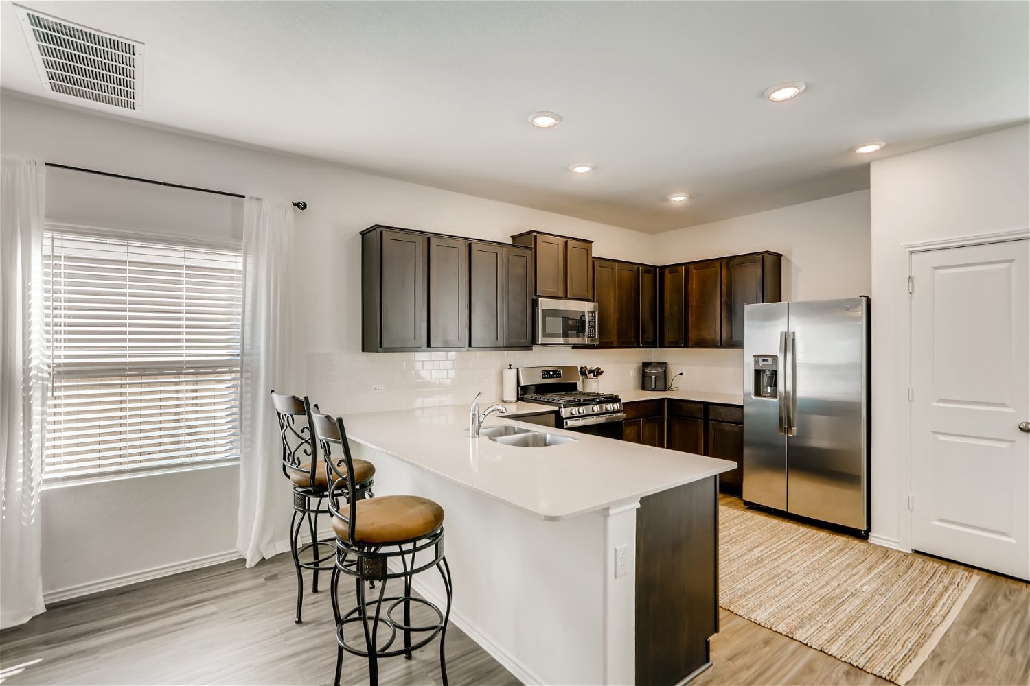 3901 Fort Collins Way Austin, TX 78744 - Photo 6 of 26 a kitchen with stainless steel appliances a refrigerator stove microwave and cabinets