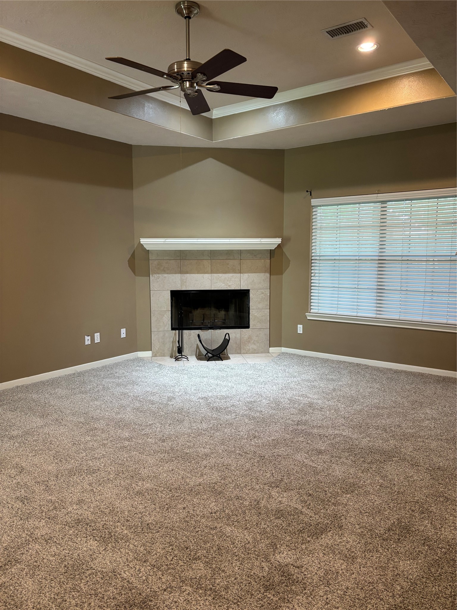 3238 Glenforest Road Montgomery, TX 77356 - Photo 9 of 41 This inviting living room features a cozy fireplace, neutral walls, plush carpeting, and a ceiling fan. The large window lets in natural light, creating a warm and welcoming atmosphere.