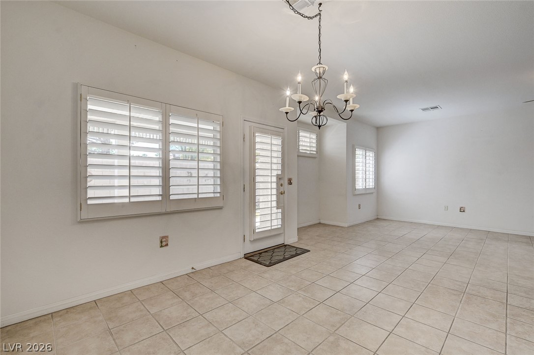 1479 Orange Jubilee Road Henderson, NV 89014 - Photo 8 of 36 A classic chandelier illuminates this spacious area with neutral tile flooring.