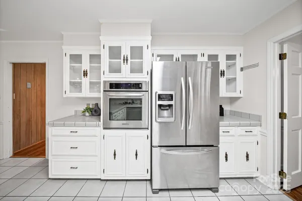 a kitchen with white cabinets and white appliances