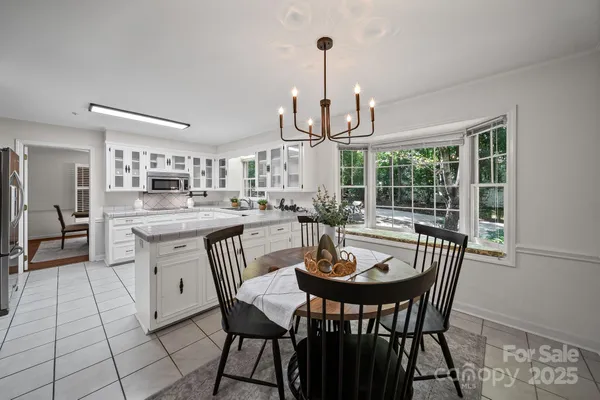 a kitchen with a dining table chairs and stove