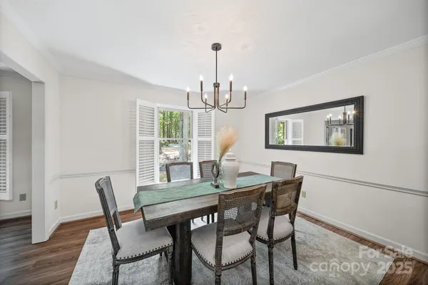 a dining room with furniture a chandelier and wooden floor