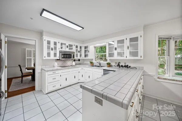 a large white kitchen with cabinets