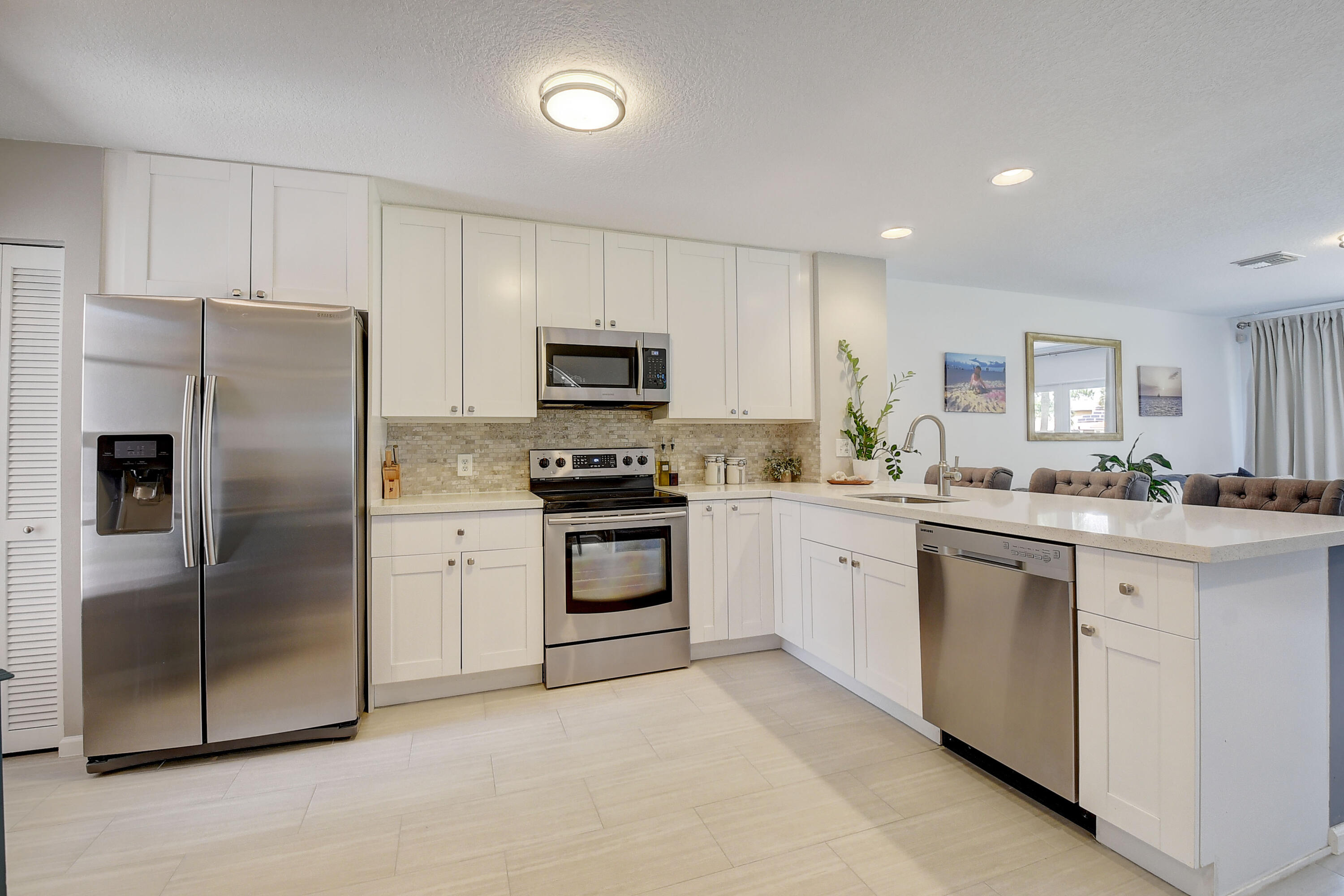 9518 Boca River Circle Boca Raton, FL 33434 - Photo 1 of 34 a kitchen with white cabinets stainless steel appliances and a counter space