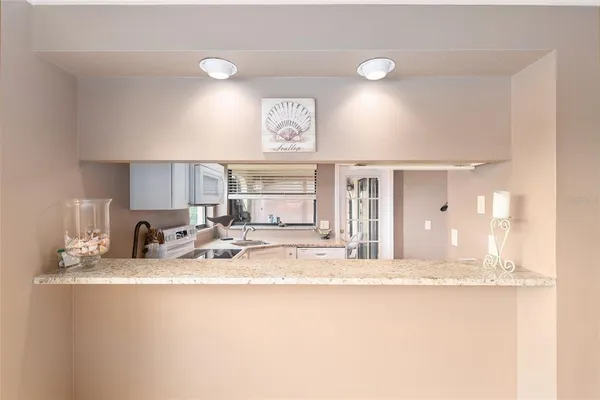 a view of a kitchen with kitchen island a sink and a large window