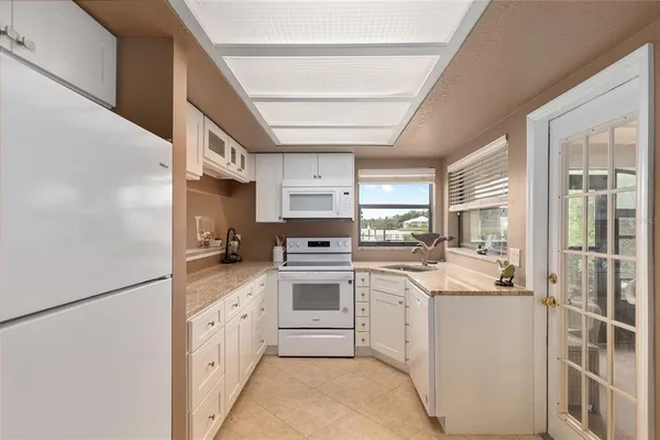 a kitchen with white cabinets and white appliances