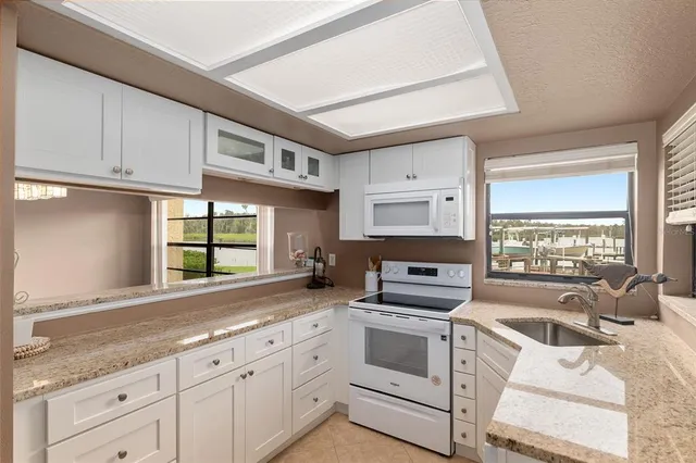 a kitchen with granite countertop a sink stainless steel appliances and cabinets